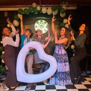 Group of people posing with hands in the air infront of a heart shaped balloon arrangement at Pagode, Canary Wharf