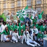 Group photo of school members in front of parliment house in London dressed in white and green