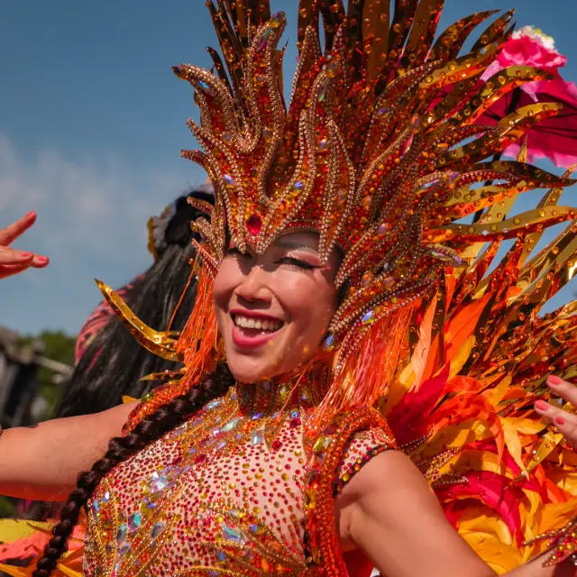 Jiyeon dancing with fire red head dress at Notting Hill Carnival 2025.