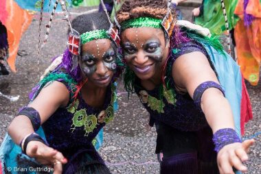 Carnival 2015 - two ladies in costume with their arms towards the camera - Copyright Brian Guttridge