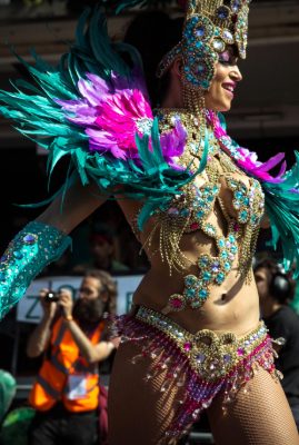 Woman in stunning feathered samba costume strutting and dancing