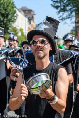 Carnival 2019 -Tam player dressed in black with a witches hat with silver stars - Copyright Brian Guttridge