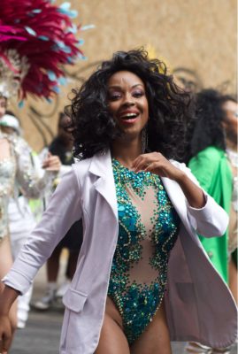 Dancing lady in a white jacket and green jewel samba outfit