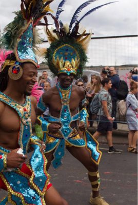 Two male dancers in street they are in mid dance and smiling and laughing