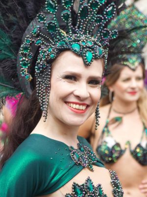 Carnival 2022 Smiling samba dancer with jewelled and feathered green head dress - Copyright Paul Lippiatt