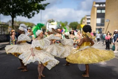 Carnival 2024 - Bainanas spinnning around with yellow dresses on -Copyright Brian Guttridge