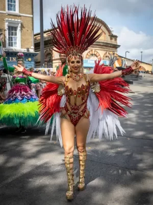 Carnival 2024 Women in a Red Samba costume smiling at camera - Copyright Brian Guttridge