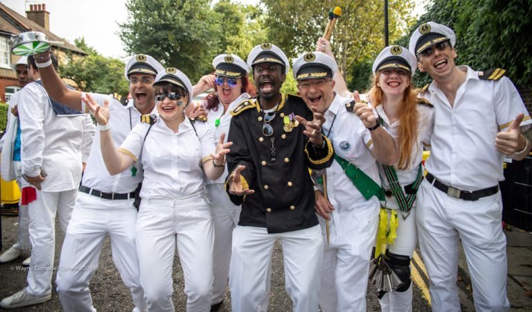 Notting Hill Carnival 2018 - bateria directors standing in sailor outfits and laughing with audience - Copyright Wayne Campbel