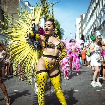 Orquidea Lima - standing in the street in full samba costume with yellow feathers